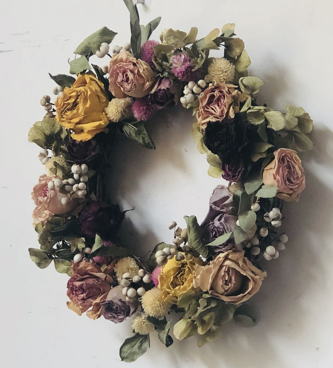 Natural Rose Round Garland: Dried roses, eucalyptus, and berries on a white background.
