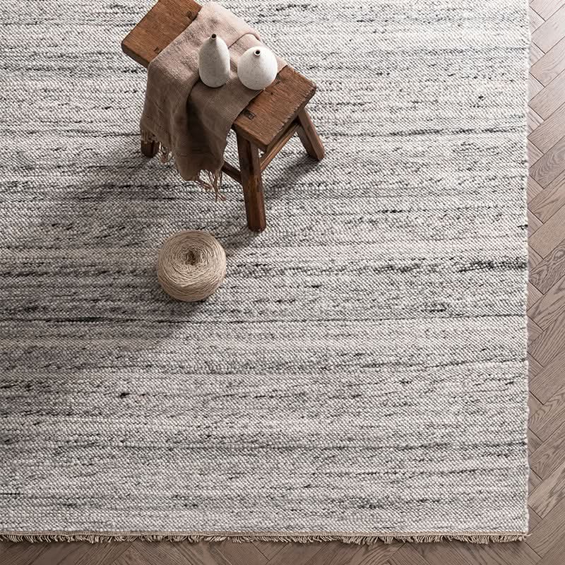 Natural Wool Carpet: textured, grey & white weave with fringed edges.