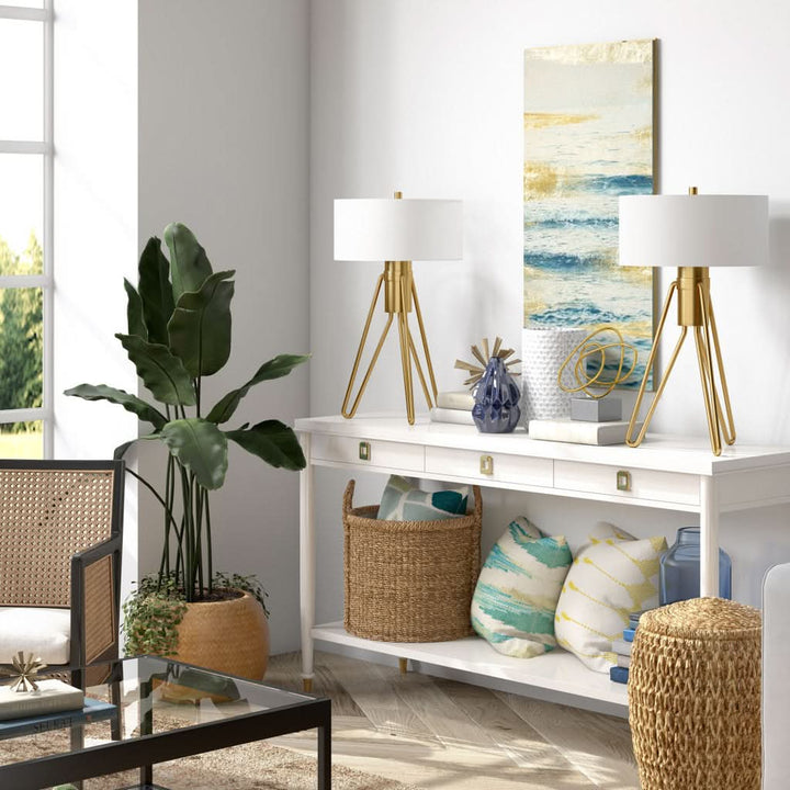 Mid Century Table Lamp Brass Tripod with white shade and gold base, on console table.