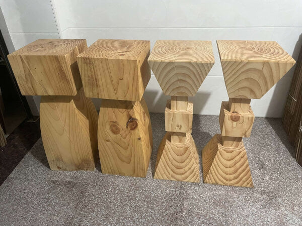 Set of 4 natural solid wood kitchen stools with unique carved bases and wood grain detail.