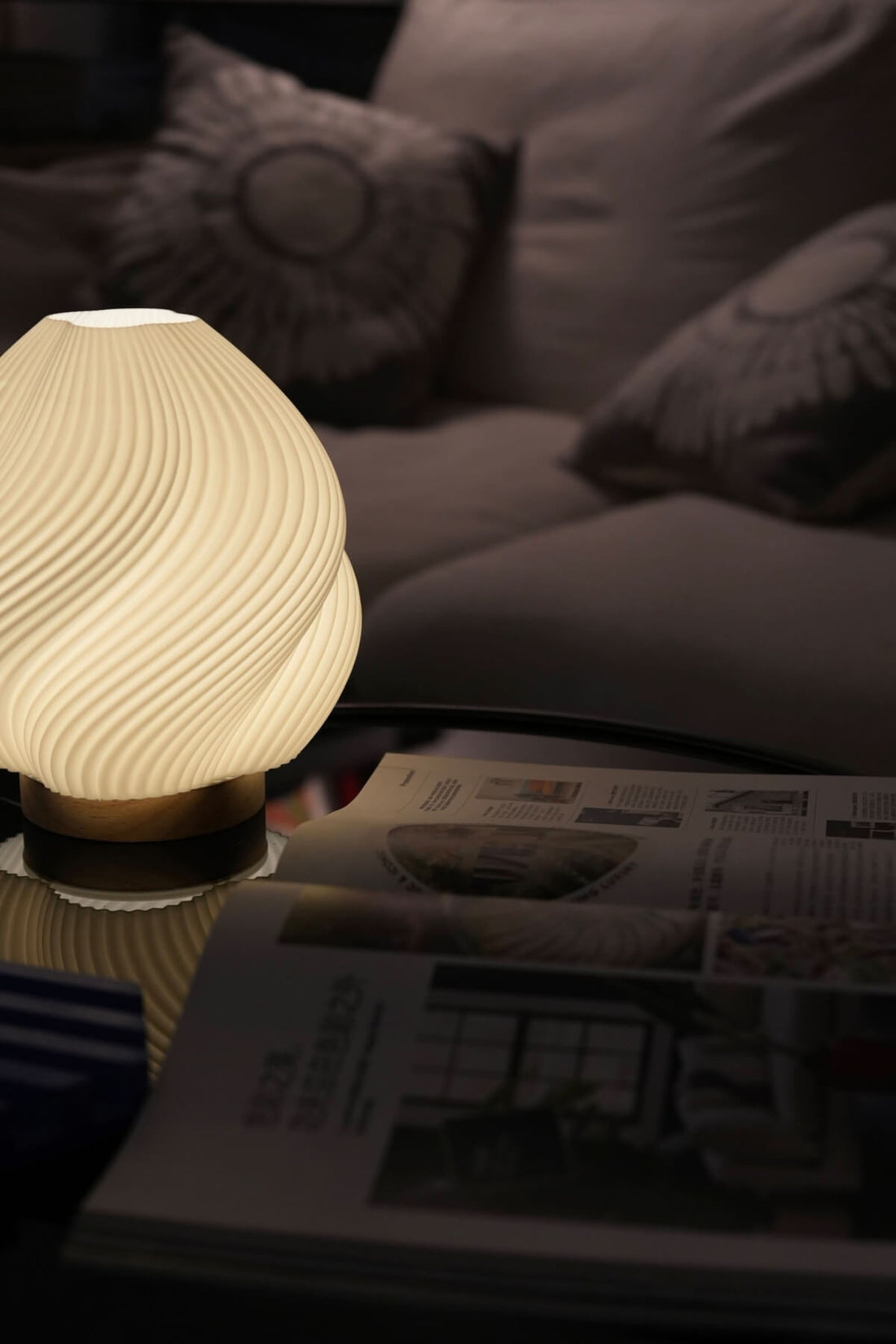 Whimsical Wave Table Lamp with wood base, illuminates a cozy living room with magazines.