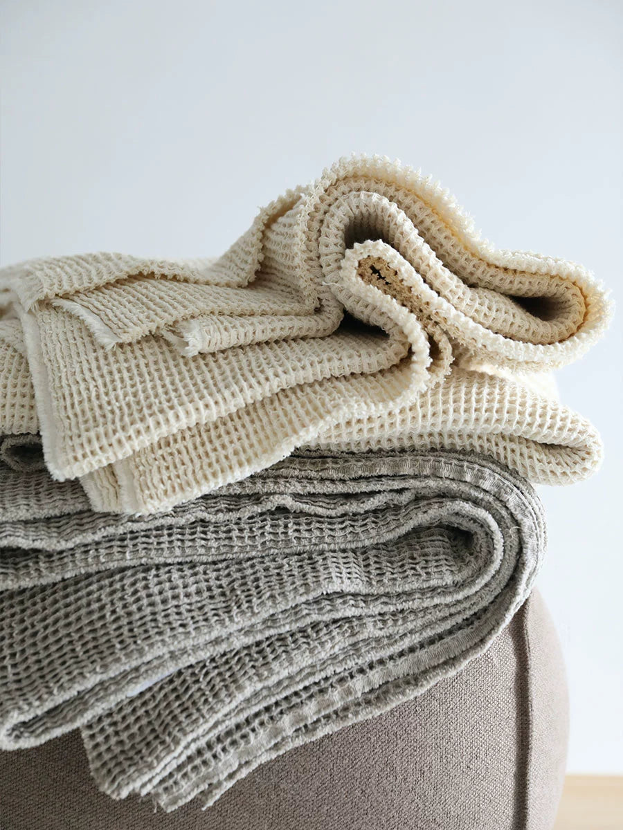 Cozy Waffle Knit Linen Throw Blankets set in beige and gray, folded on a textured surface.