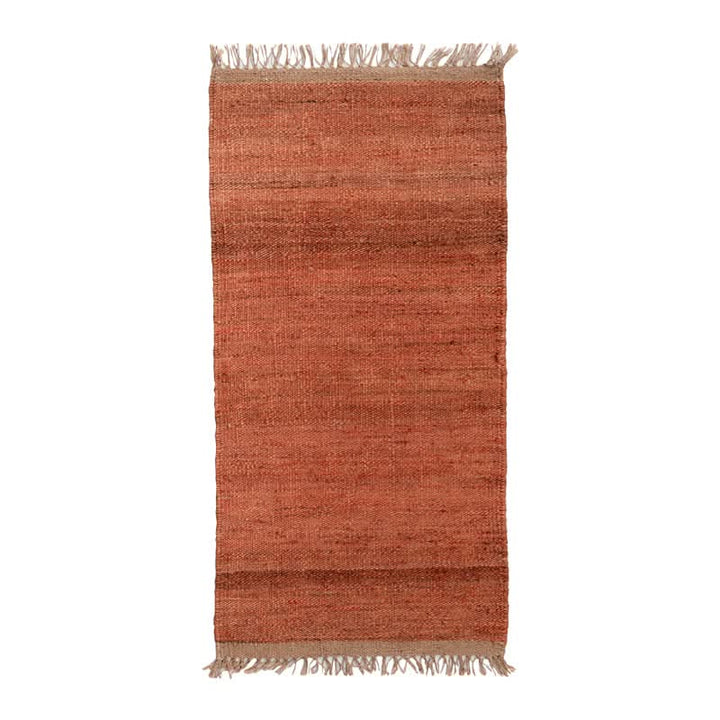 Handwoven Jute Rug in natural rustic tones with fringed edges.