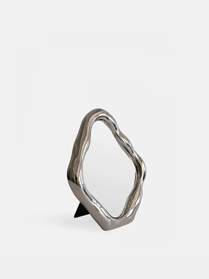 Modern abstract silver metal vanity mirror with organic shape, desk decor.
