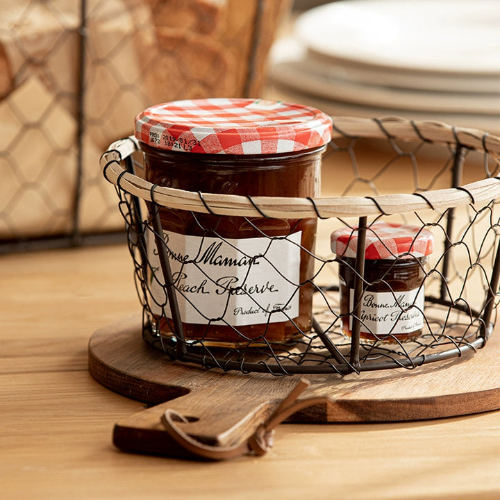 Vintage Style Black Wire Woven Bread Basket with jam jars on wooden board