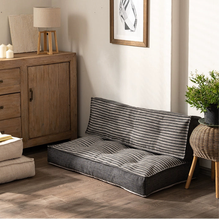 Modern minimalist floor sofa with striped fabric in a cozy room setting.