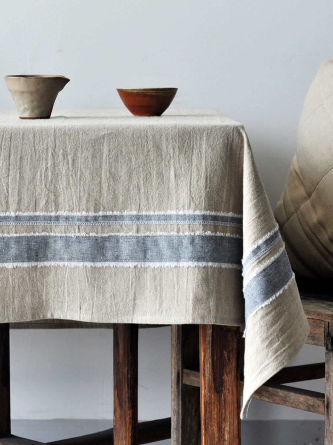 Rustic Linen Tablecloth with Stripes: Natural beige farmhouse style linen with gray stripes and frayed edges.