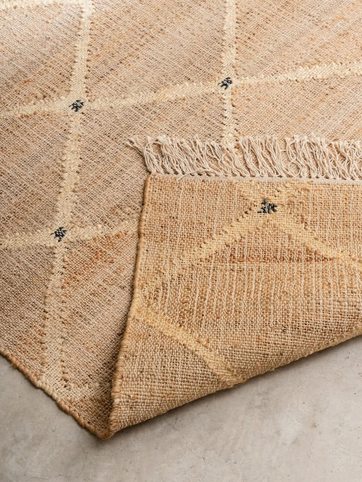 Beige Indian Jute Rug with diamond pattern and frayed edges, a natural fiber home decor accent.