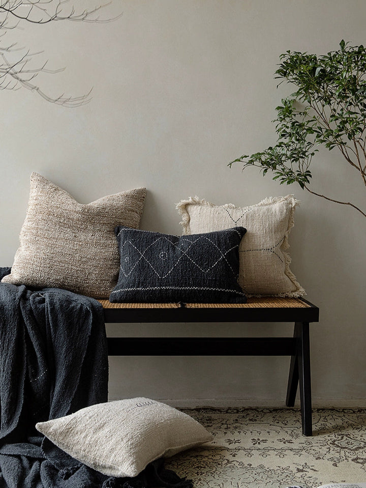 Boho Throw Pillows & Blanket Set: beige, black, natural woven cushions and dark blanket on bench.