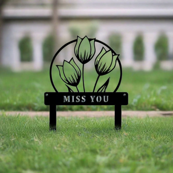 Black metal customizable floral garden decor with "MISS YOU" text, set in green grass.