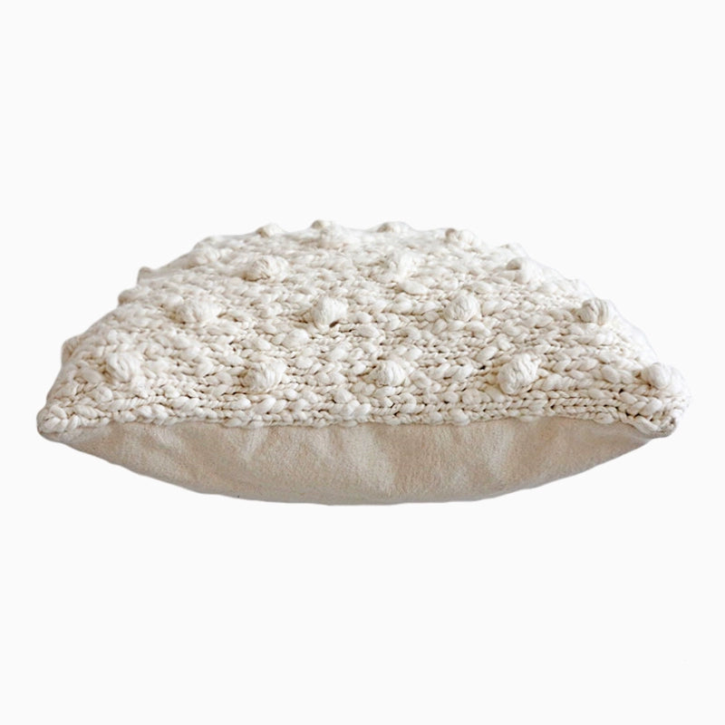 Cozy Knitted Throw Pillows: Cream textured knit pillow with tufted bobble design.