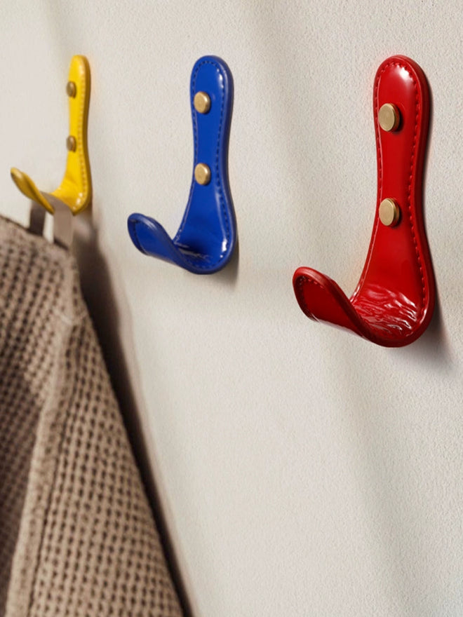 Colorful leather wall hooks in red, blue, and yellow dopamine decor colors add charm to any home.