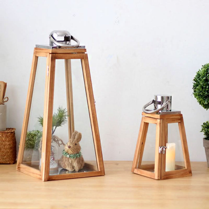 Triangular Rustic Wooden Lantern with glass panels and metal accents on a wooden table.