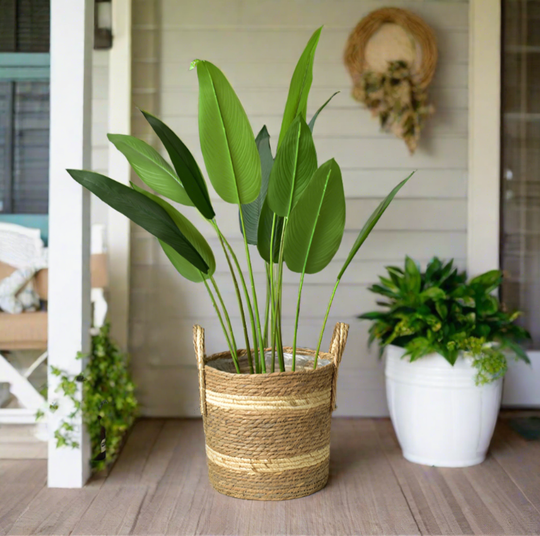 Woven plant basket with handles, featuring natural straw and cream stripes. Home decor accent.