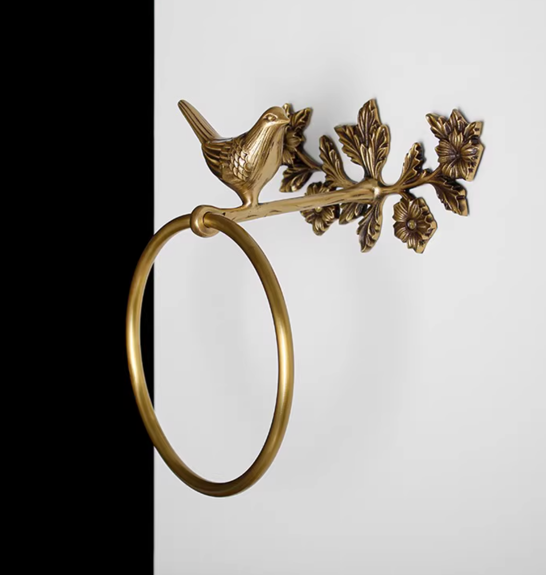 Brass bird towel rack and toilet paper holder on a branch.