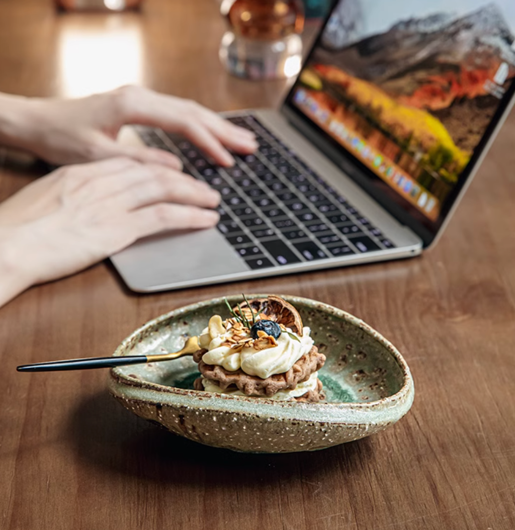 Artisan Green Dinnerware in textured ceramic, holding a layered dessert with fork.