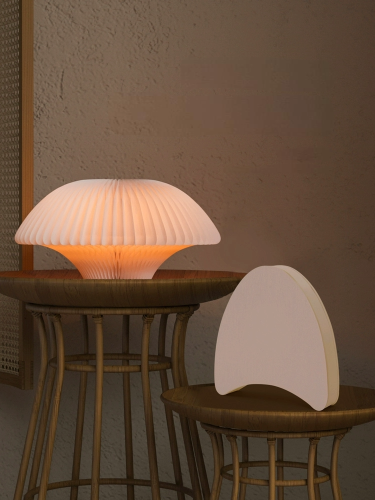 Origami bell-shaped paper bedside lamp glows warmly on a woven table.