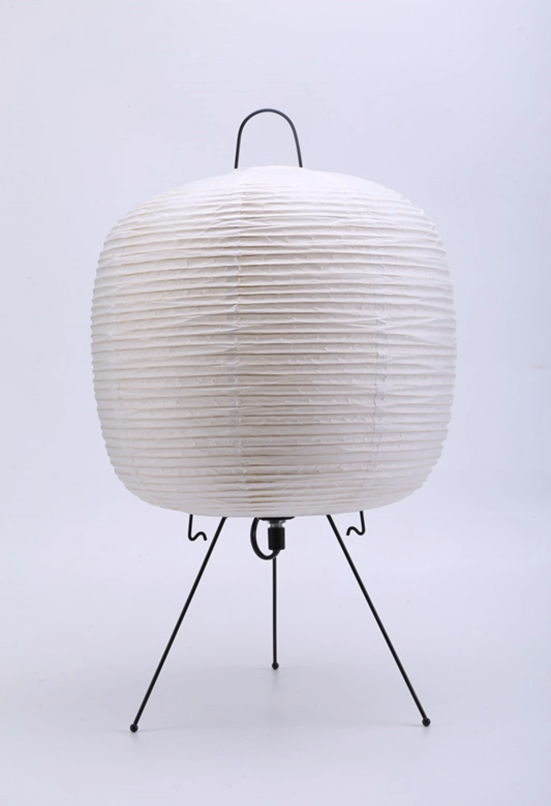 White paper floor lamp with black tripod base and metal handle for home decor.