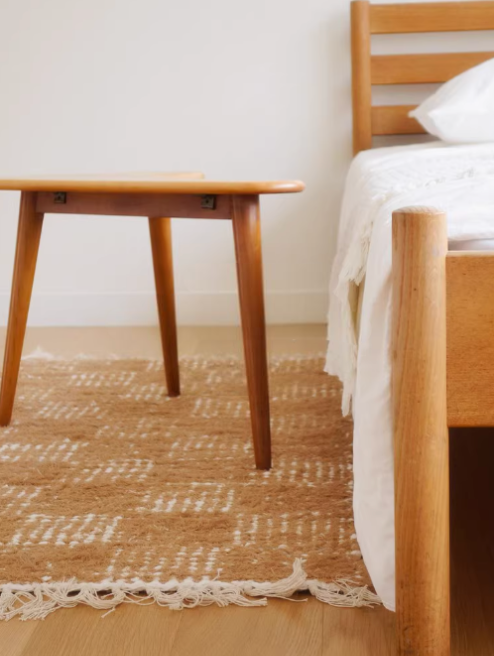 Handwoven cotton checkered rug in warm brown & cream, 2.3x4.6, in a bedroom setting.
