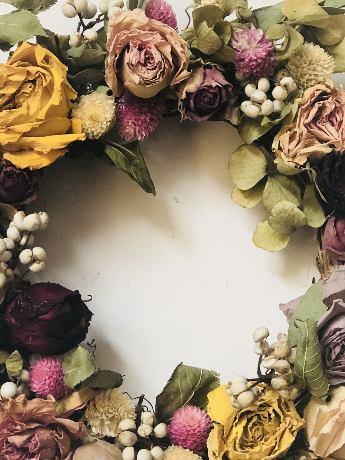 Natural Rose Round Garland: A mixed dried floral wreath with roses, berries, and greenery in muted tones.