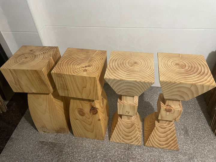 Set of 4 natural wood kitchen stools with visible grain on speckled floor.