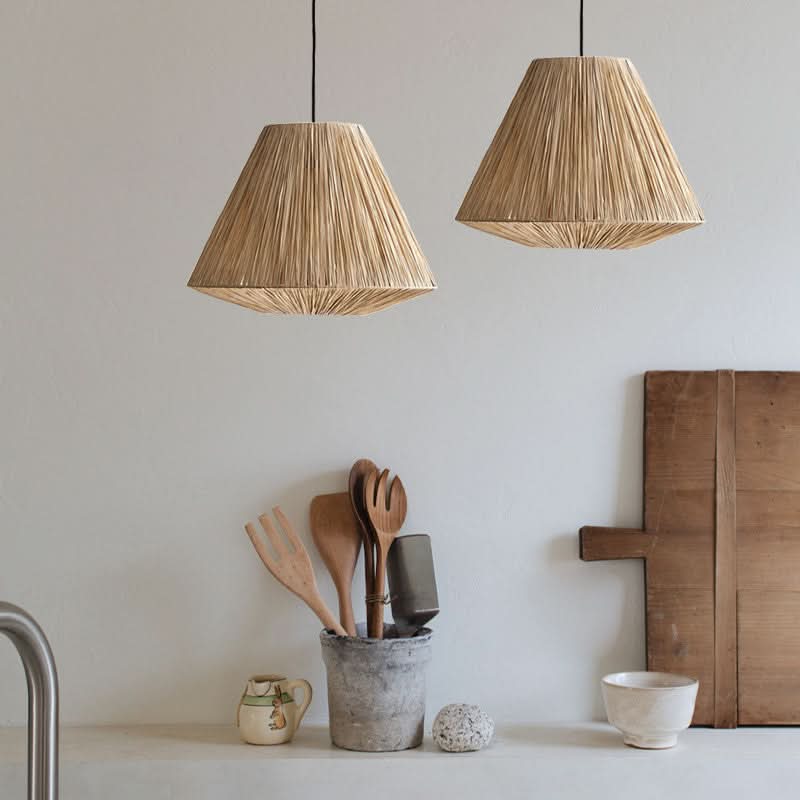 Natural raffia lampshade, triangle shape, hanging in a bright kitchen.