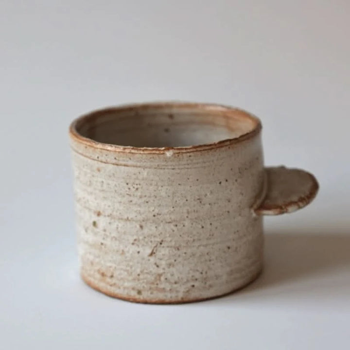 Rough pottery ceramic mug with straight handle, speckled natural finish, home decor.
