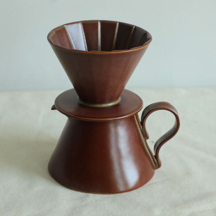 Brown ceramic coffee brewer, textile folded style cup set for home decor.