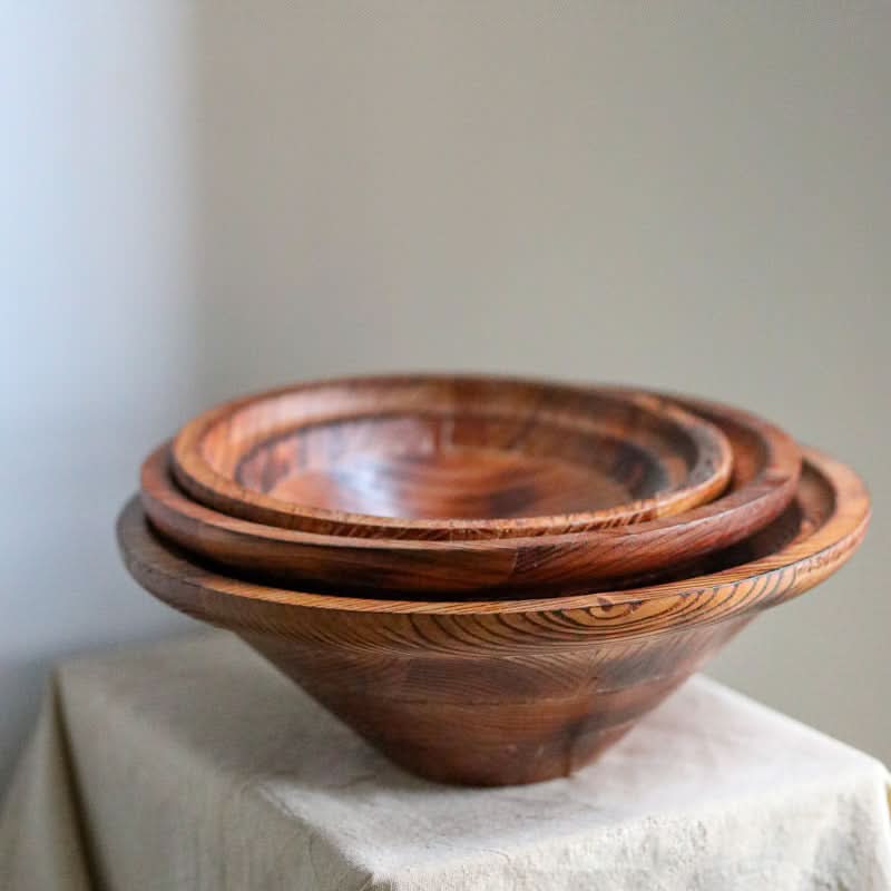 Handmade Retro Bowl: set of three dark wood bowls with visible grain, displayed on a linen cloth.
