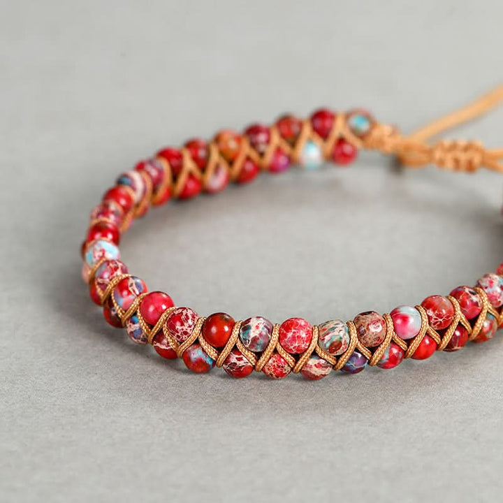 Red, pink, and blue speckled emperor stone bracelet with 4mm beads and natural cord detail.