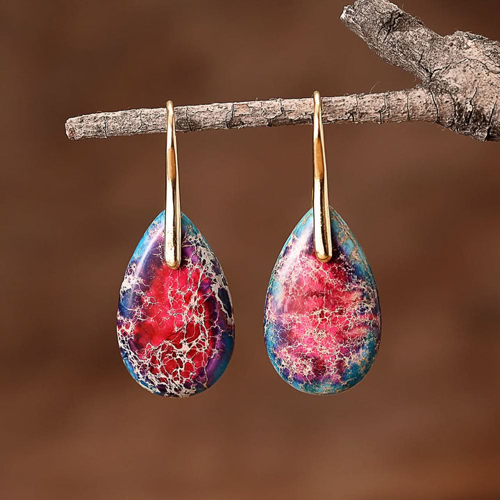 Teardrop Stone Earrings: Blue, red, and white marbled stones with gold findings on a branch.