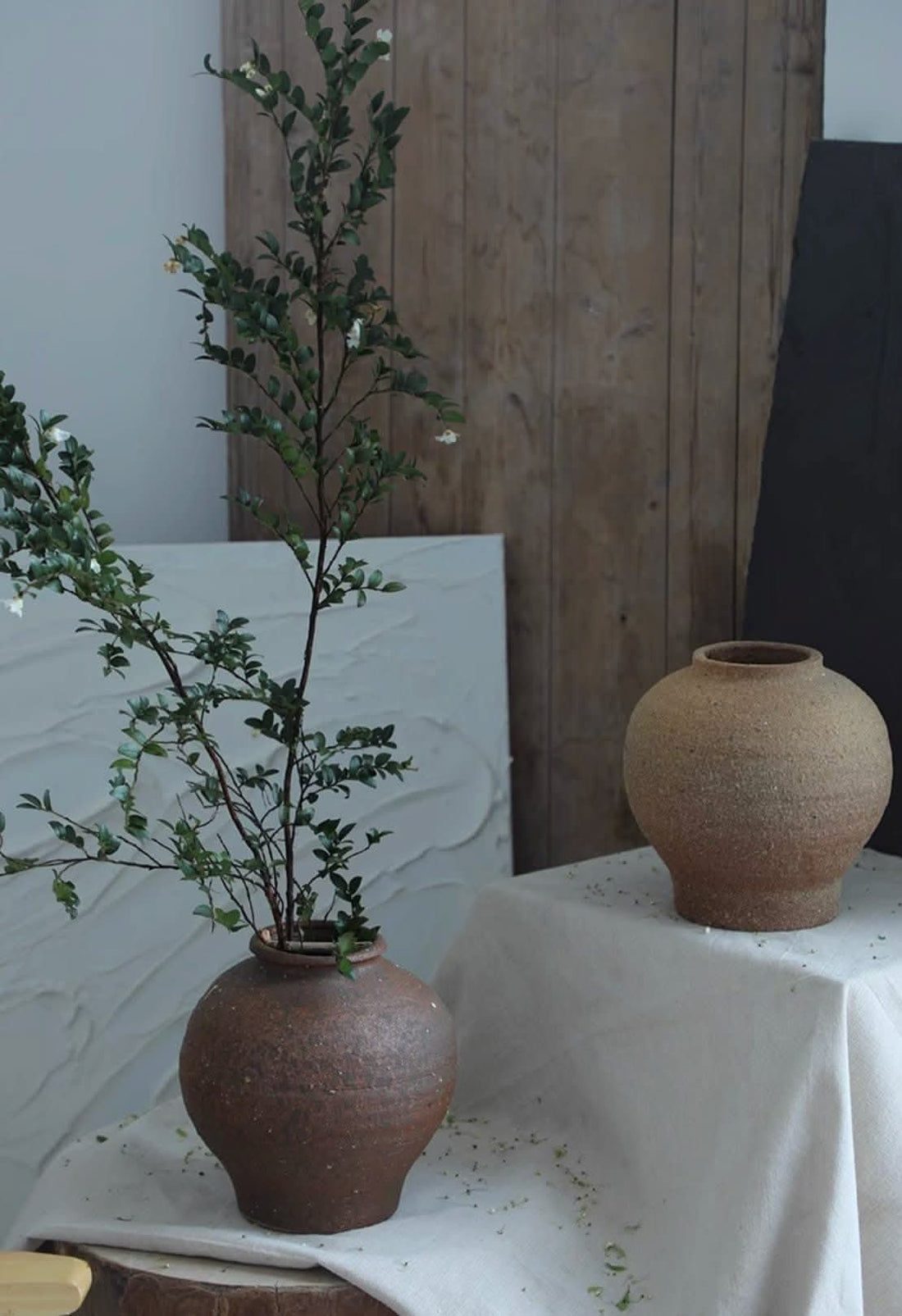 Danish-style Rough Earthenware Vases in warm brown, holding green branches.
