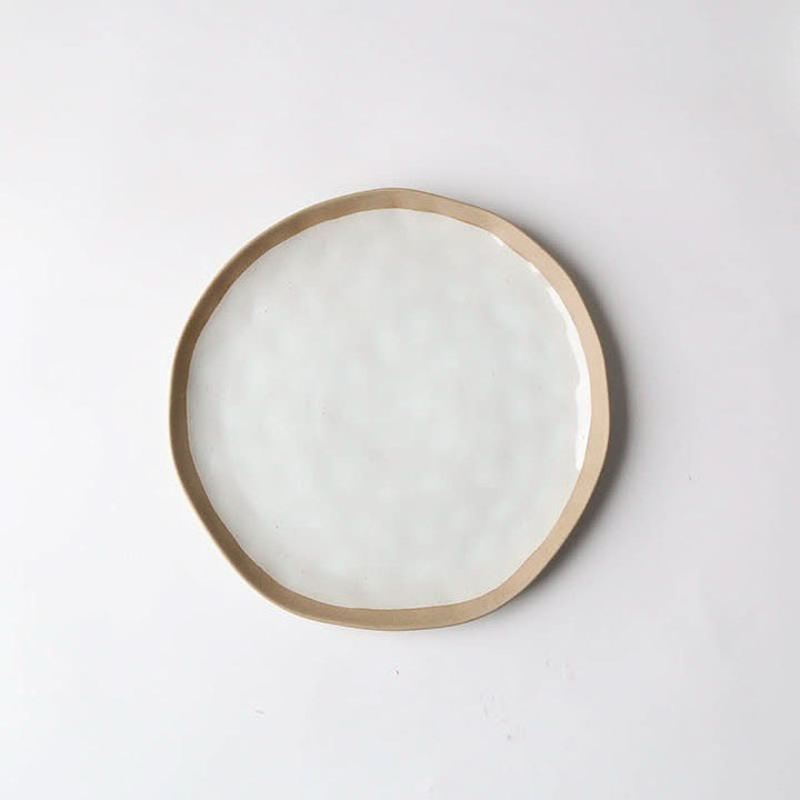 Irregular clay Japanese dinner plate with white glaze and tan rim, 20.2cm.