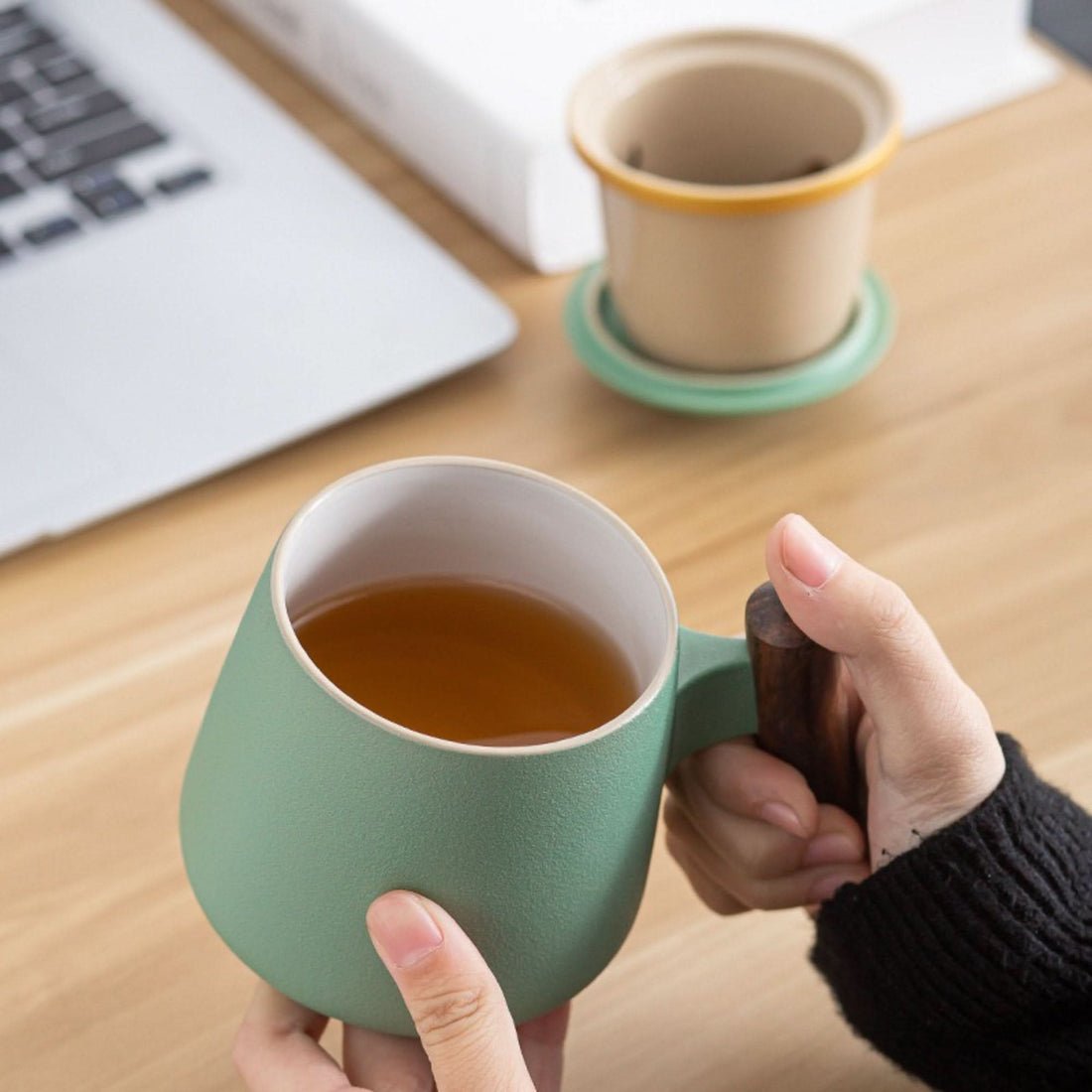 Green Minimalist Japanese Mug 10.1oz with wooden handle, on a desk next to a laptop.