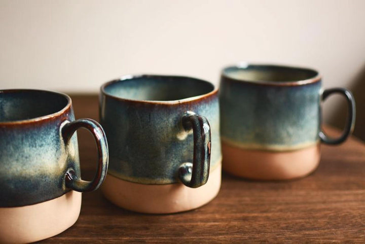 Reactive Glazed Pottery Mug 13.5oz: blue & tan ceramics on wood surface