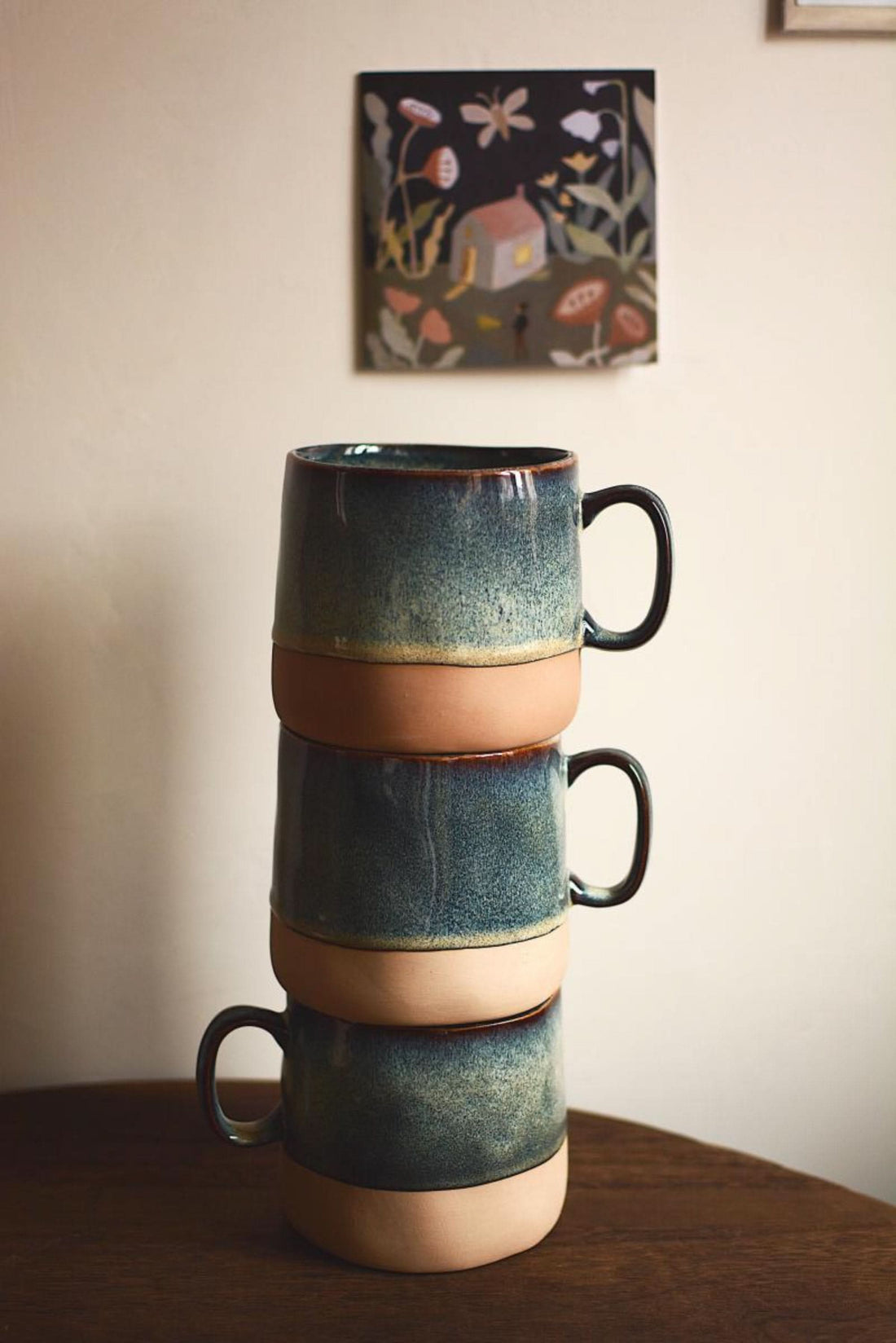 Stack of reactive glazed pottery mugs, blue & tan, modern ceramic latte mug.