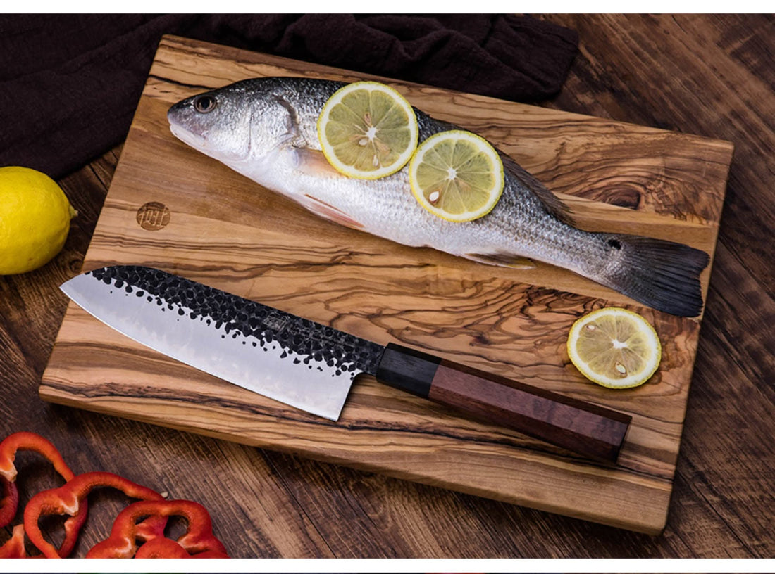 Japanese Forged Knife, Santoku, Kiritsuke, Chef Knife on olive wood cutting board with fish & lemon.