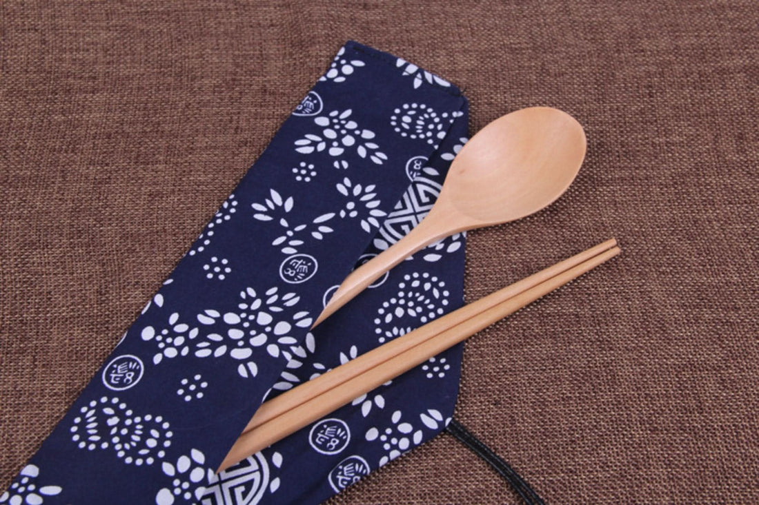 Natural wooden Japanese wood cooking utensils with spoon set & fabric case on brown burlap.