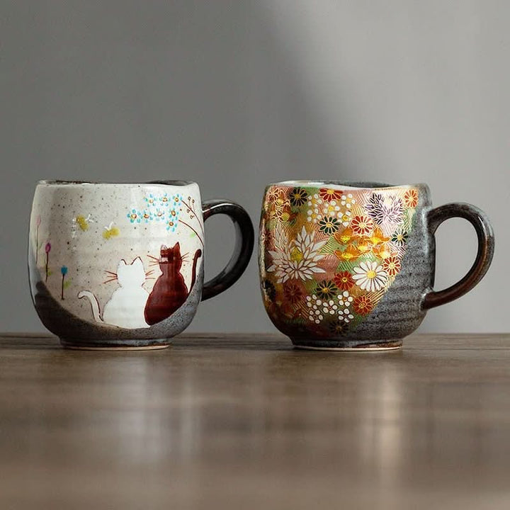 Japanese Kutani-yaki stoneware mugs, one with cats, one with floral pattern.