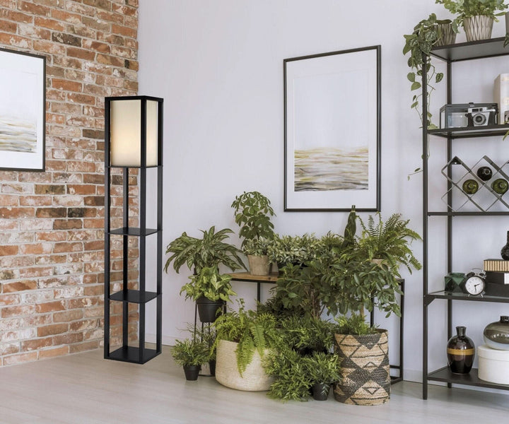 Japanese inspired linen floor lamp with storage in a room with plants and brick wall.
