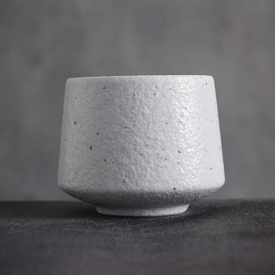 Textured gray Japanese tea cup with speckled detail, minimalist home decor.