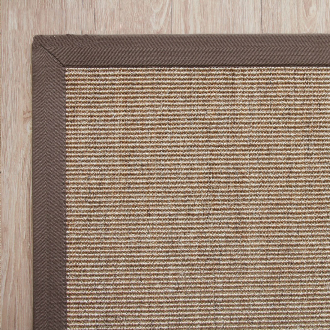 Jug Rug With Covered Borders, natural fiber woven rug with brown binding on wooden floor.