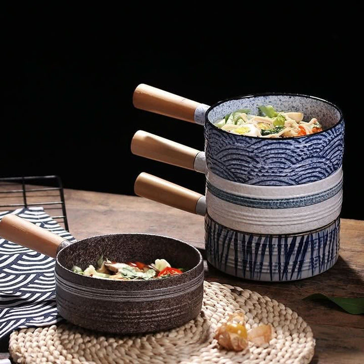 Rustic Stoneware Baking Plates: Japanese style ceramic bowls with wooden handles, filled with food.