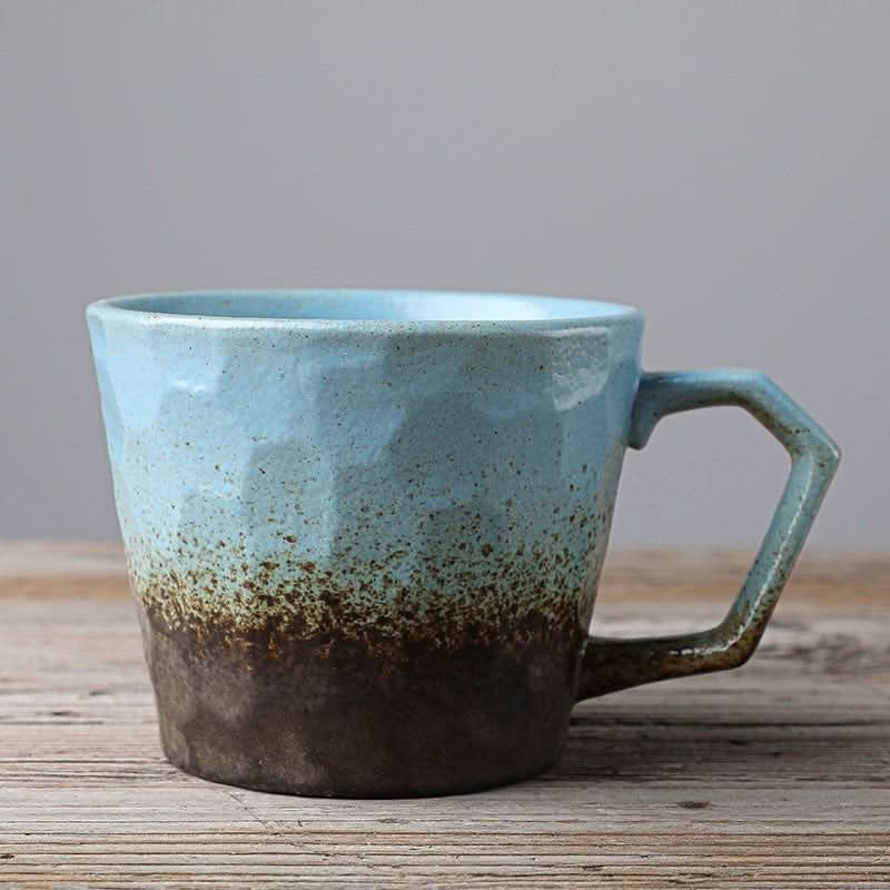 Blue and brown stoneware coffee cup vintage Japanese style mug on wooden surface.