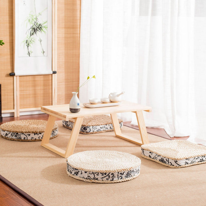 Round straw floor pouf with fabric decor, perfect for boho or rustic settings.
