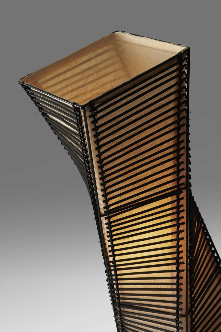 Twisted black cane and natural paper shade table lamp with mid-century Japanese design.