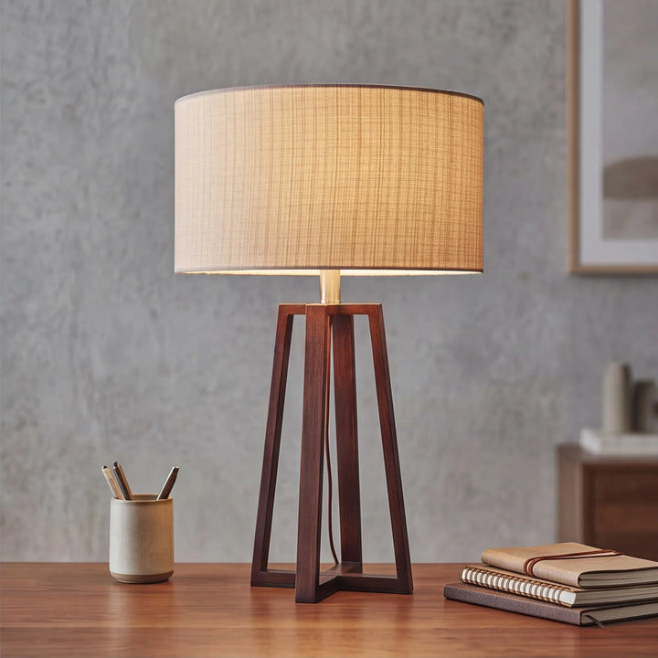 Walnut linen table lamp glowing warmly on wooden desk in Japandi home office with grey wall