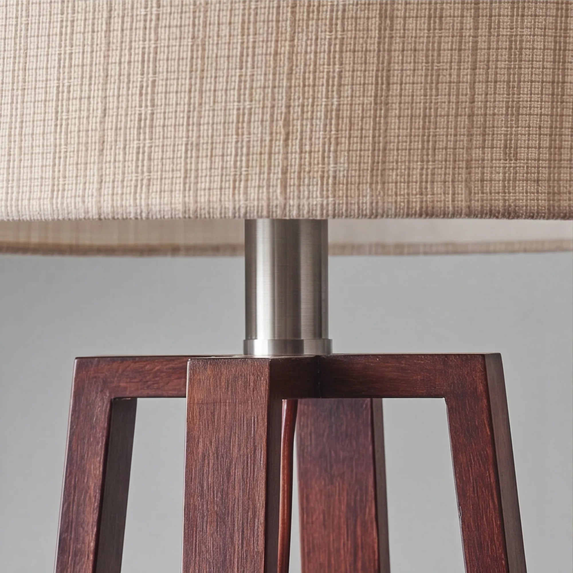 Close-up of linen shade cross-weave and walnut wood grain on slatted table lamp base