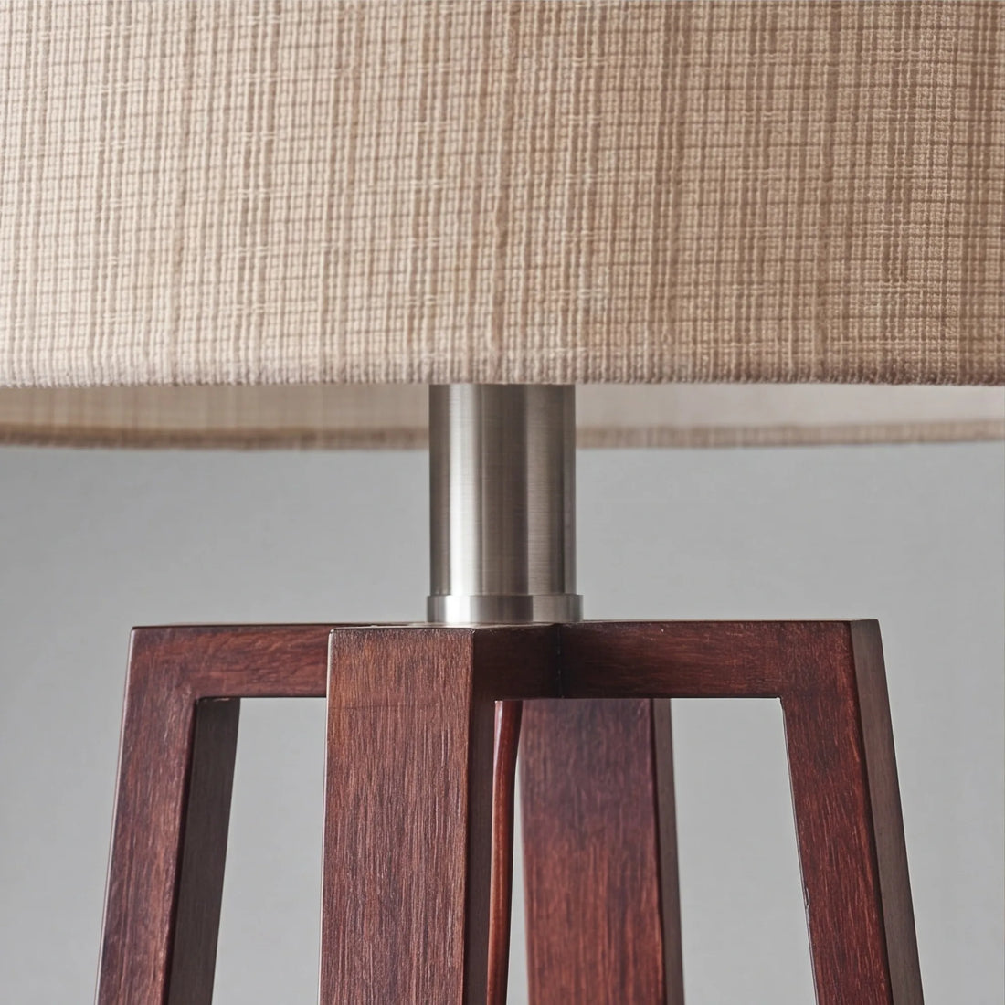 Close-up of linen shade cross-weave and walnut wood grain on slatted table lamp base