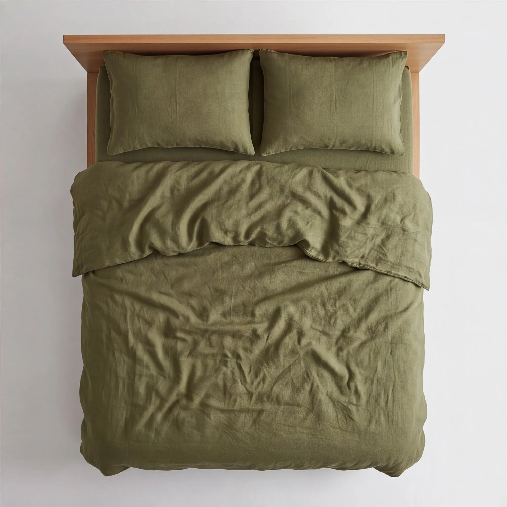 Top-down view of olive green linen bedding on queen platform bed showing full mattress coverage and natural wrinkles